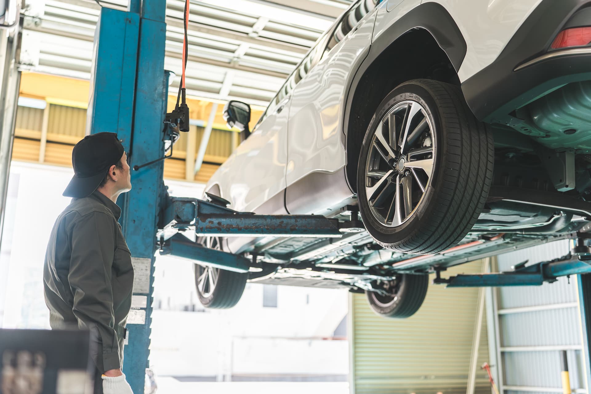 リフトする車をチェックする整備士